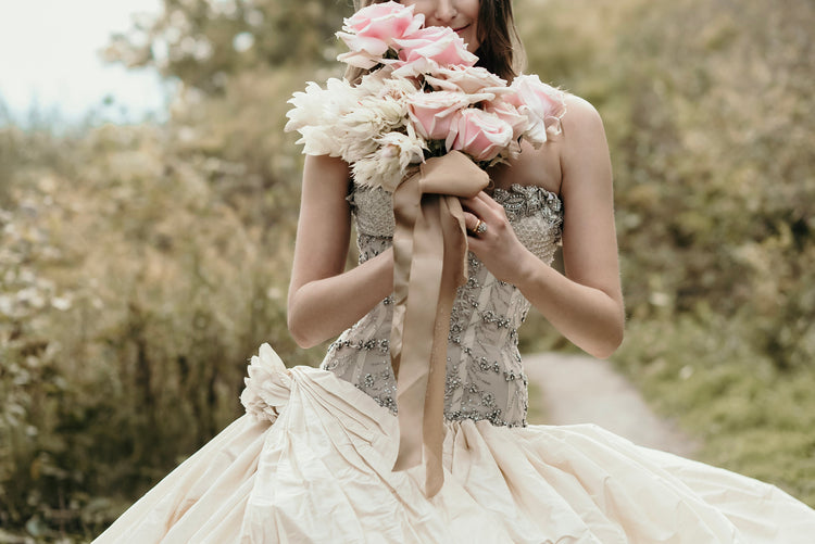 Bride With Pink Wedding Bouquet Photo The bride holds her bouquet up to her face to smell the aroma of a pink rose.
